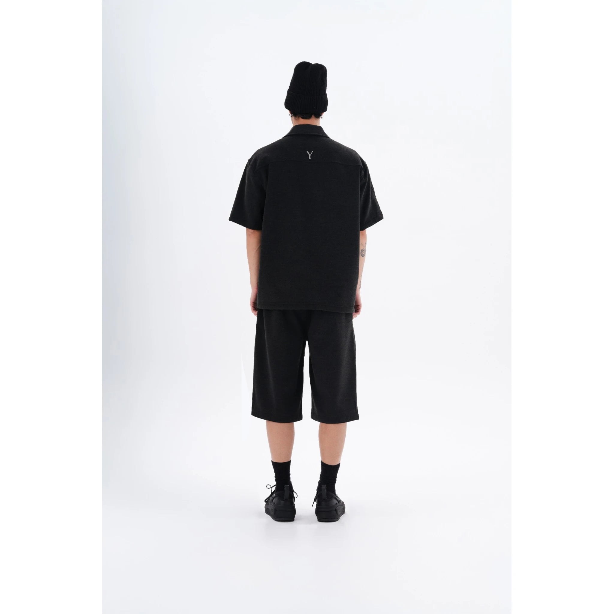 "Back view of the YAD Dark Grey Bermuda Shorts on a model - Showcasing the clean and minimalist design with a relaxed fit for contemporary urban wear."